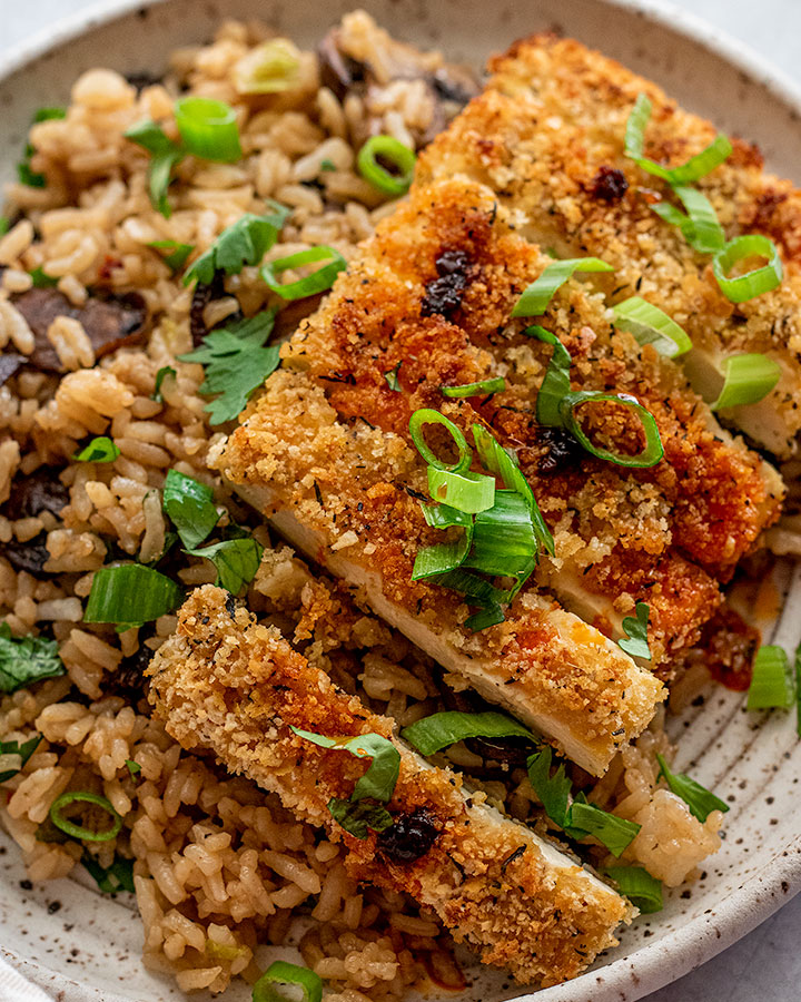 Close up of crispy panko crusted tofu topped with chili oil and scallions.