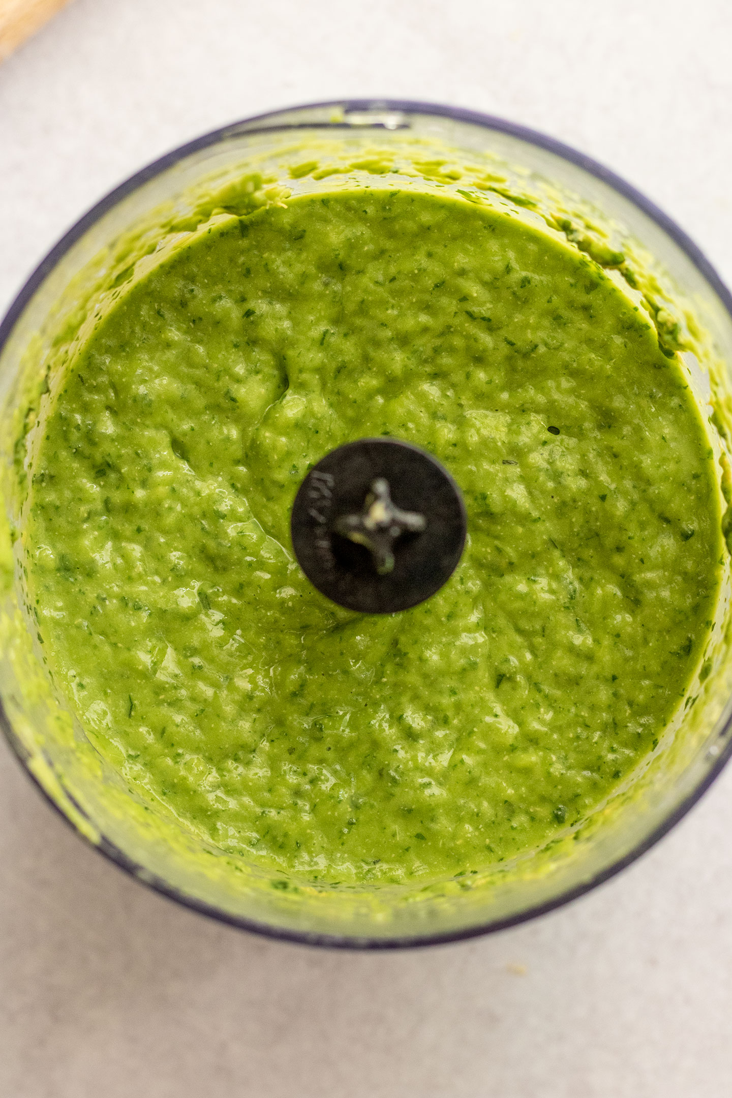 Blended green goddess dressing in a small food processor.