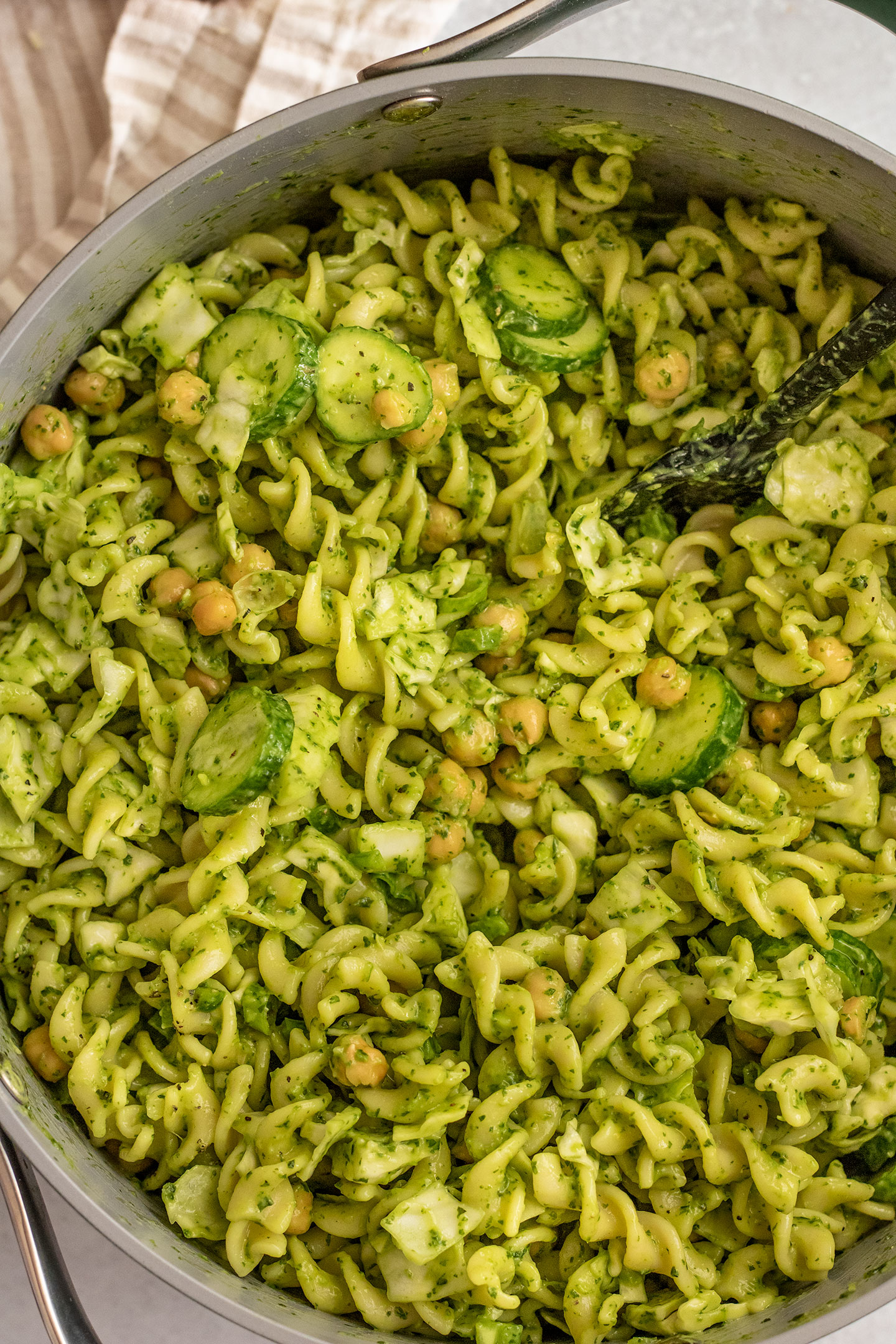 Green goddess dressing fully mixed together with pasta, veggies and chickpeas.