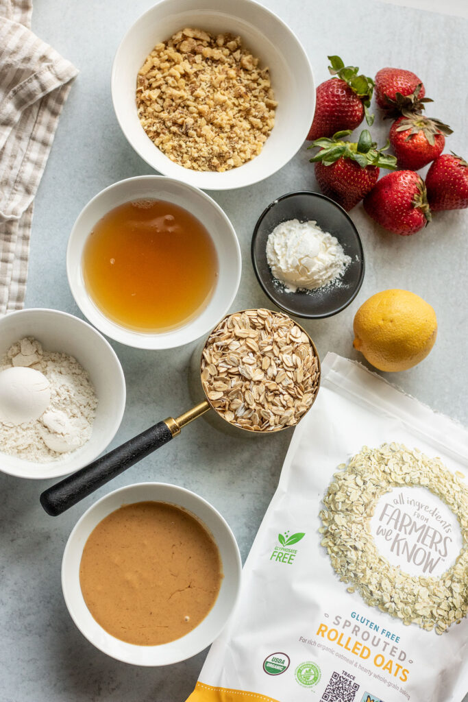 The main ingredients for the oat crumble which includes rolled oats from One Degree Organics, a bowl of nut butter, cornstarch, oat flour, maple syrup, lemon, strawberries and walnuts.