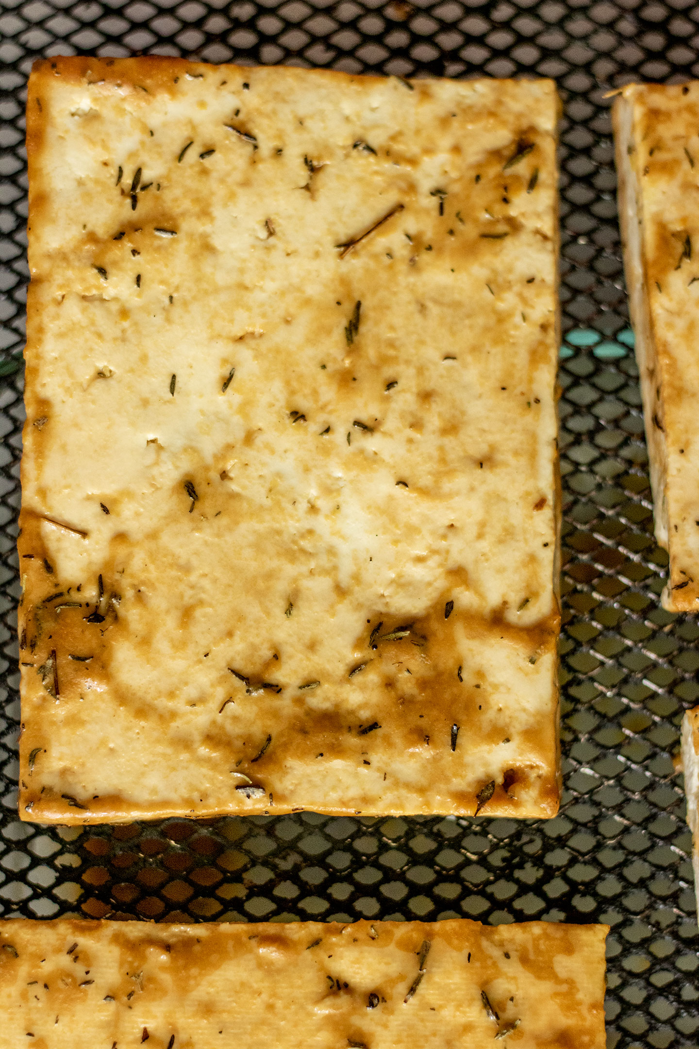 Batter coated tofu placed in an air-fryer basket.