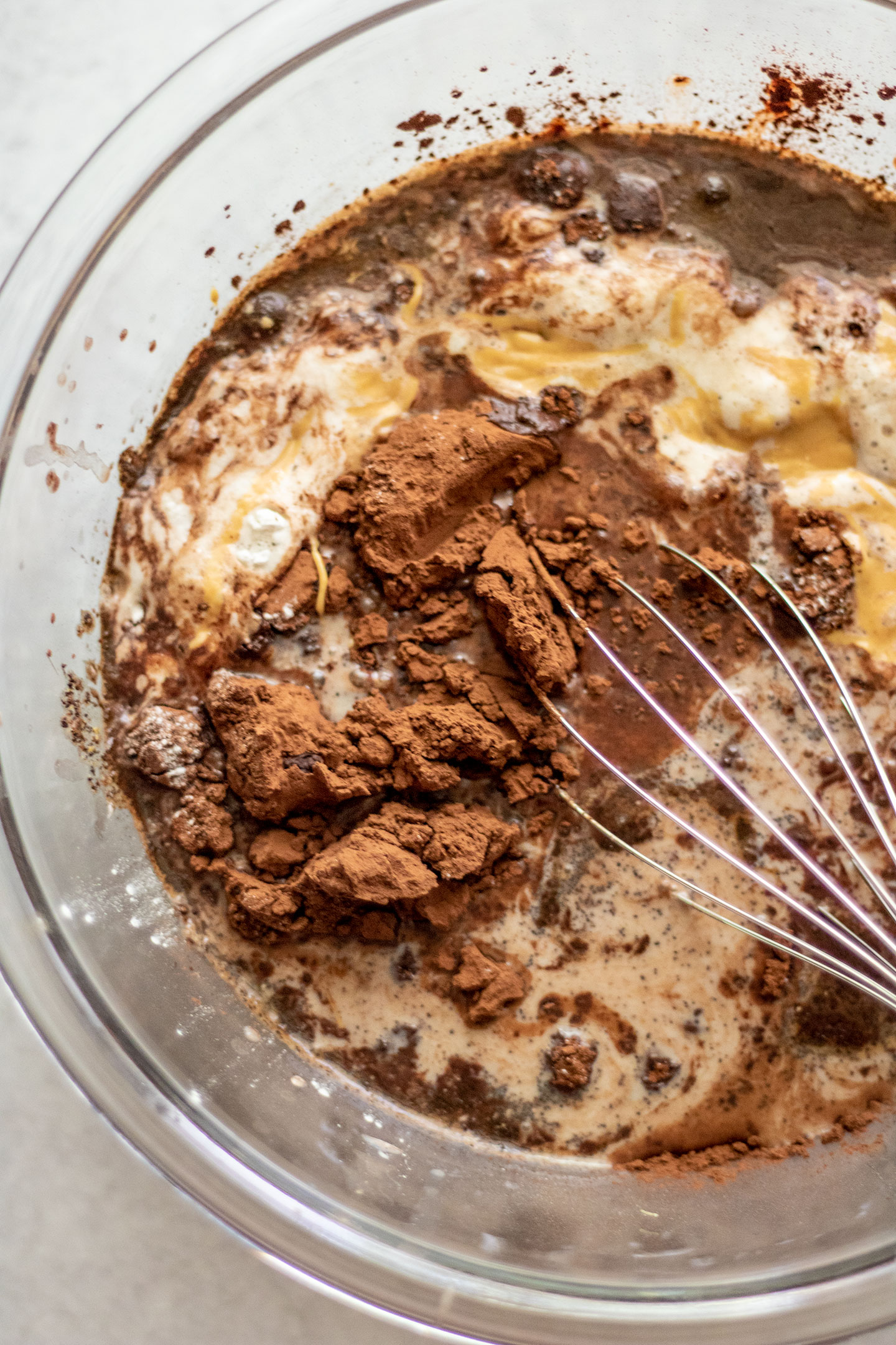 Mixing the chocolate batter together in a glass bowl with a metal whisk.
