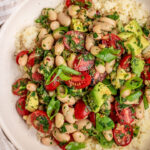 Cannellini bean salad topped over freshly cooked couscous and topped with extra herbs and scallions.