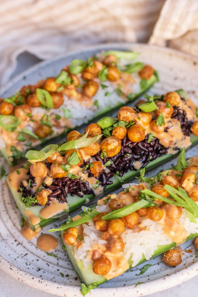 Three rice stuffed cucumber boats topped with roasted chickpeas, scallions and tahini sauce.