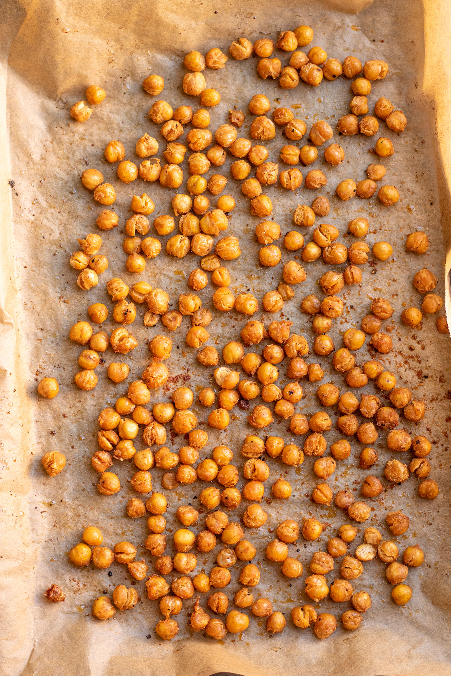 Crispy chickpeas after roasting in the oven on a parchment lined sheet pan.