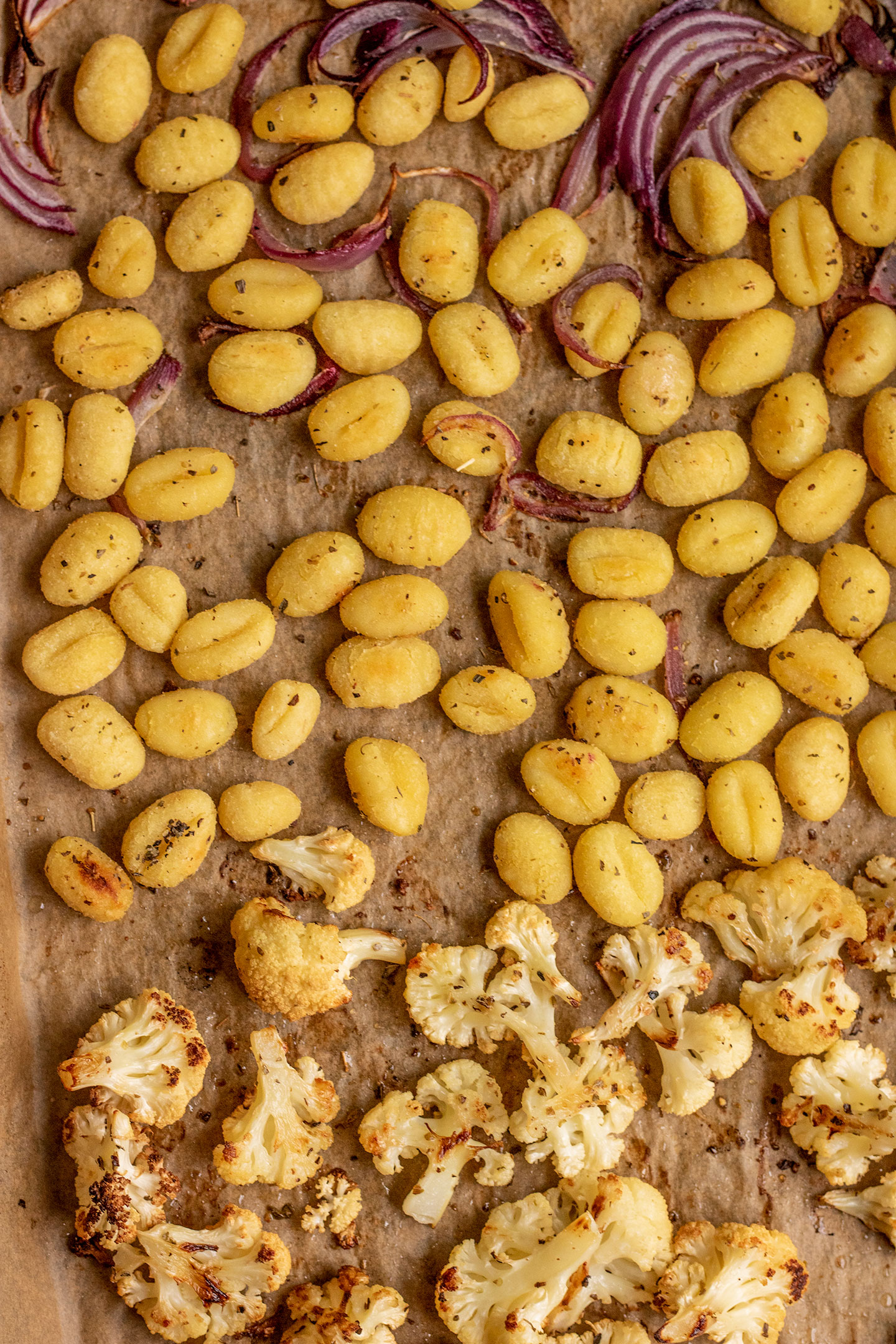 Sheet pan with roasted gnocchi, cauliflower and onions.