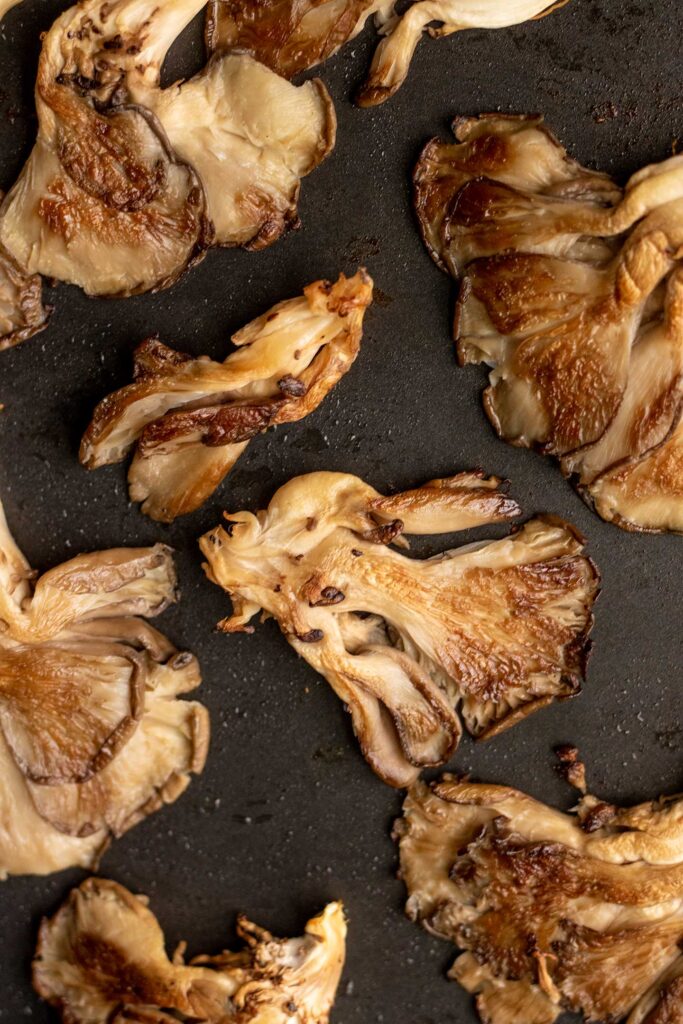 Pan fried oyster mushrooms that are flattened.