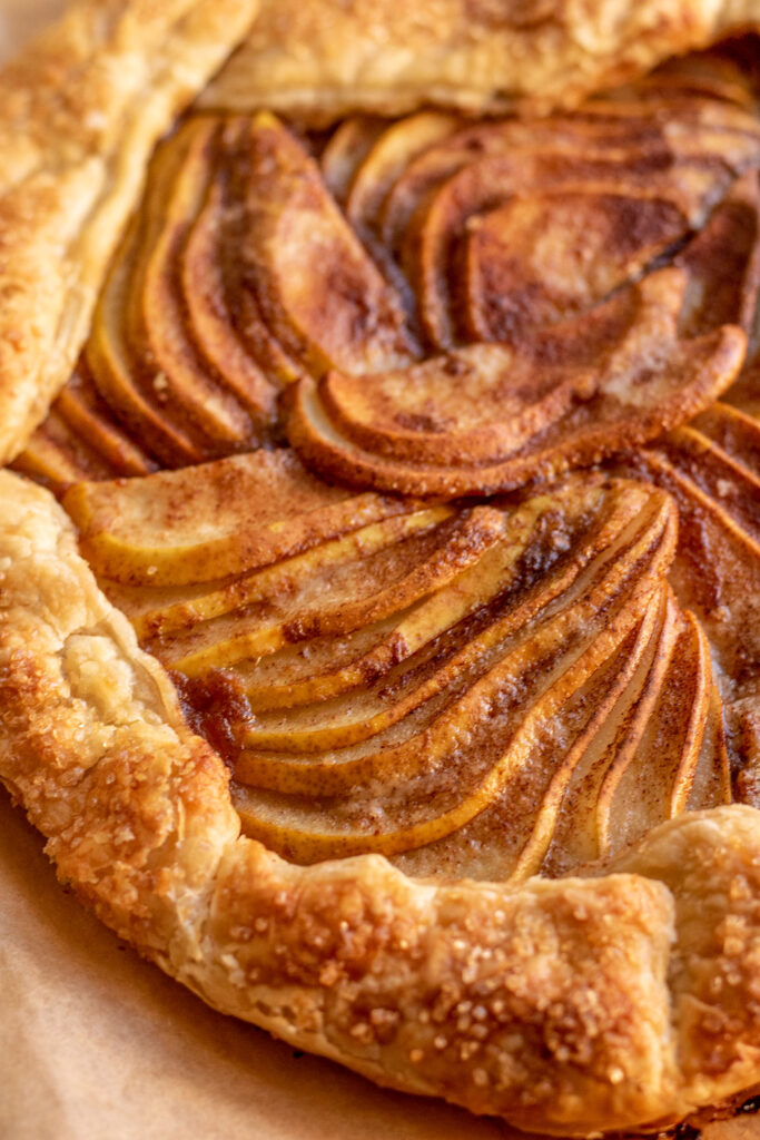 Side view of a fully baked puff pastry galette with pear filling.