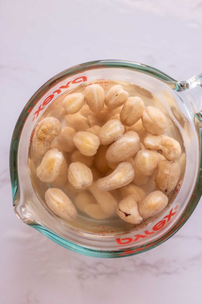 Soaking cashews in water in a measuring cup.