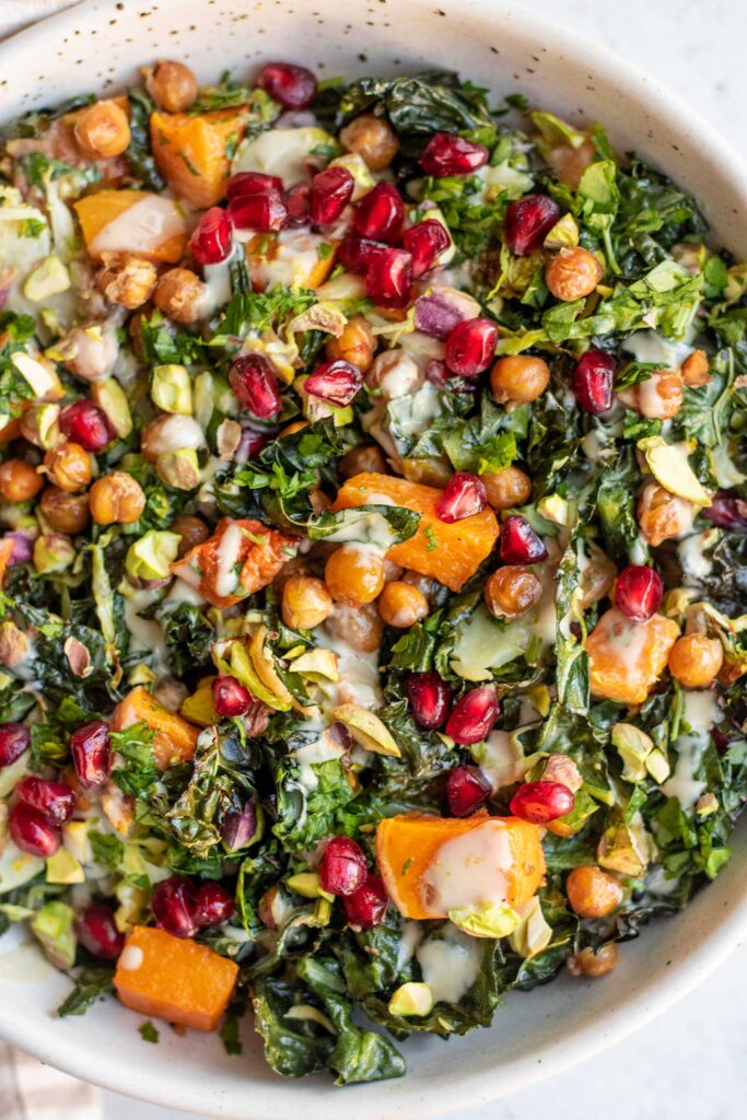 Warm salad topped with butternut squash, chickpeas, pomegranate, pistachios and dressing.