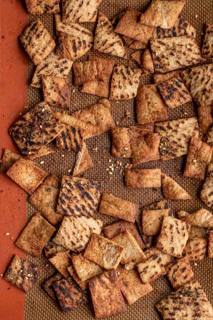 Freshly baked pita chips out of the oven on a baking tray.