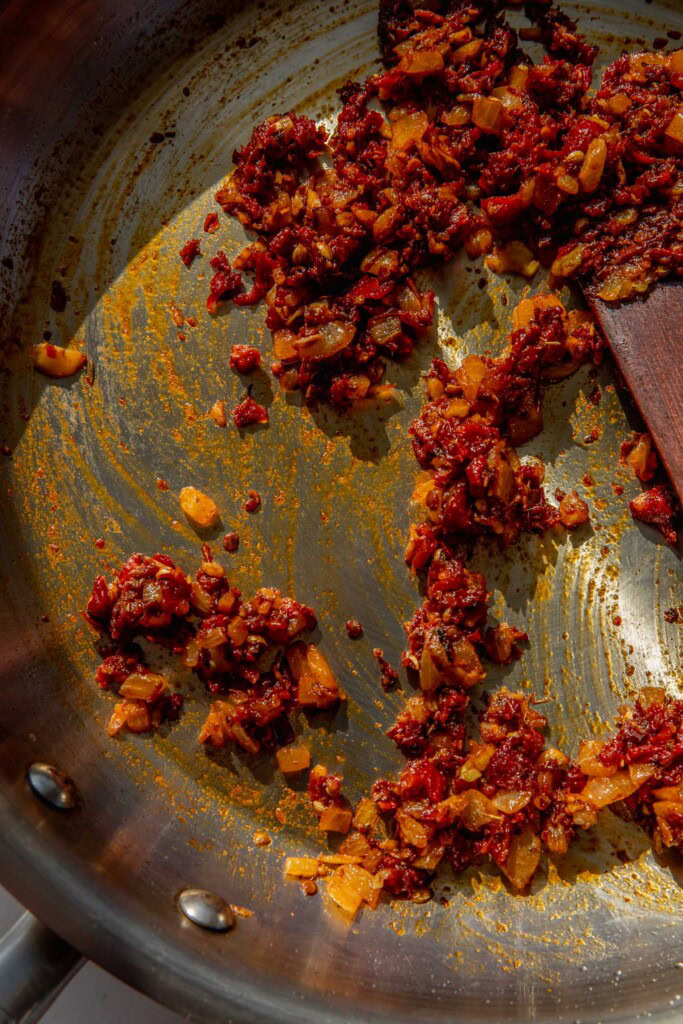 Sauteing the peppers and tomatoes together with the spices until nice and red in the pan.