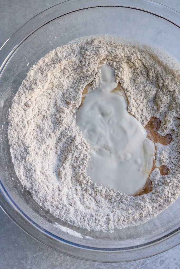 Combining the dry pancake ingredients with the wet ingredients in a bowl.