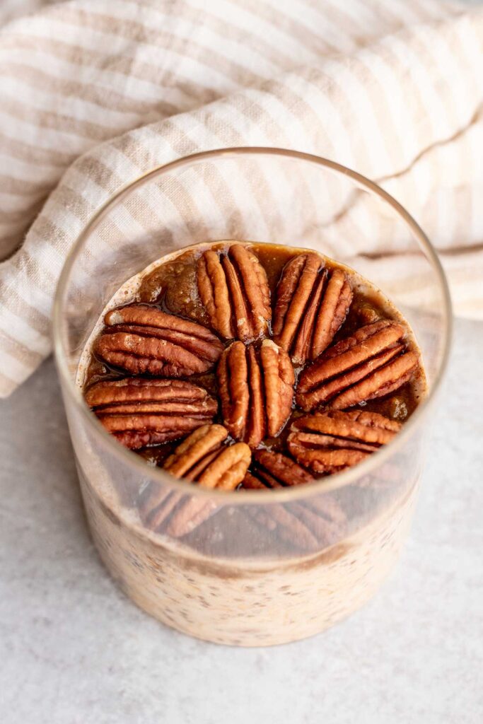 Jar of pecan pie overnight oats topped with the classic pecan design on top.