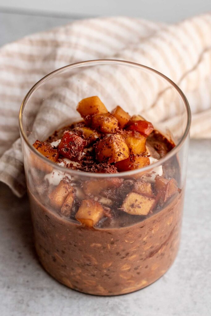 Chocolate gingerbread oats in a jar topped with yogurt and sauteed pears.