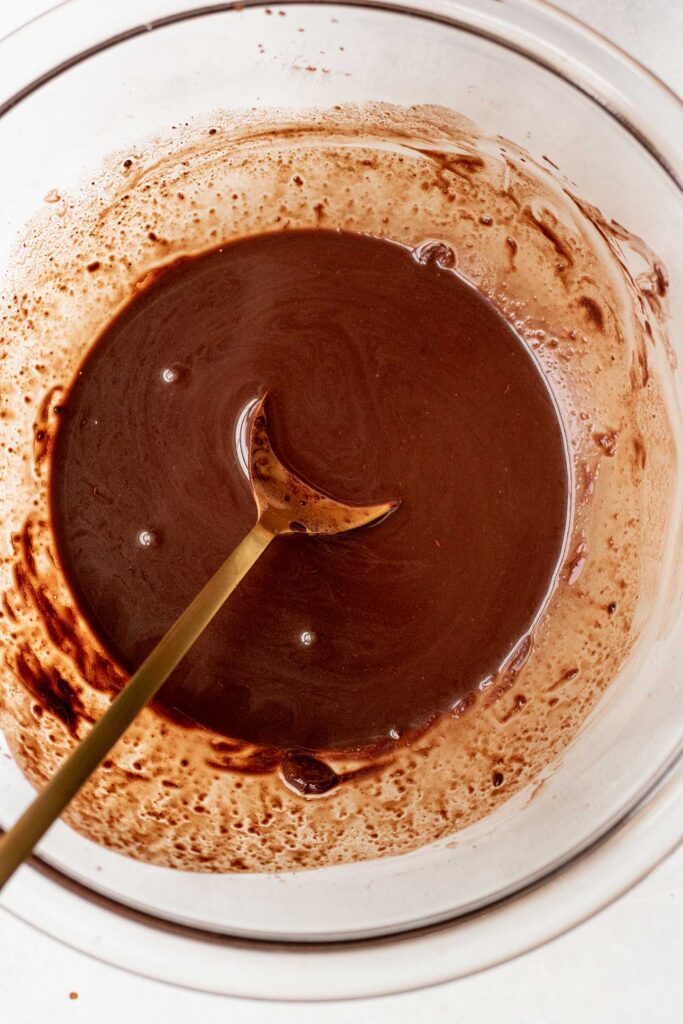 Blooming the cocoa powder with hot coffee in a bowl.