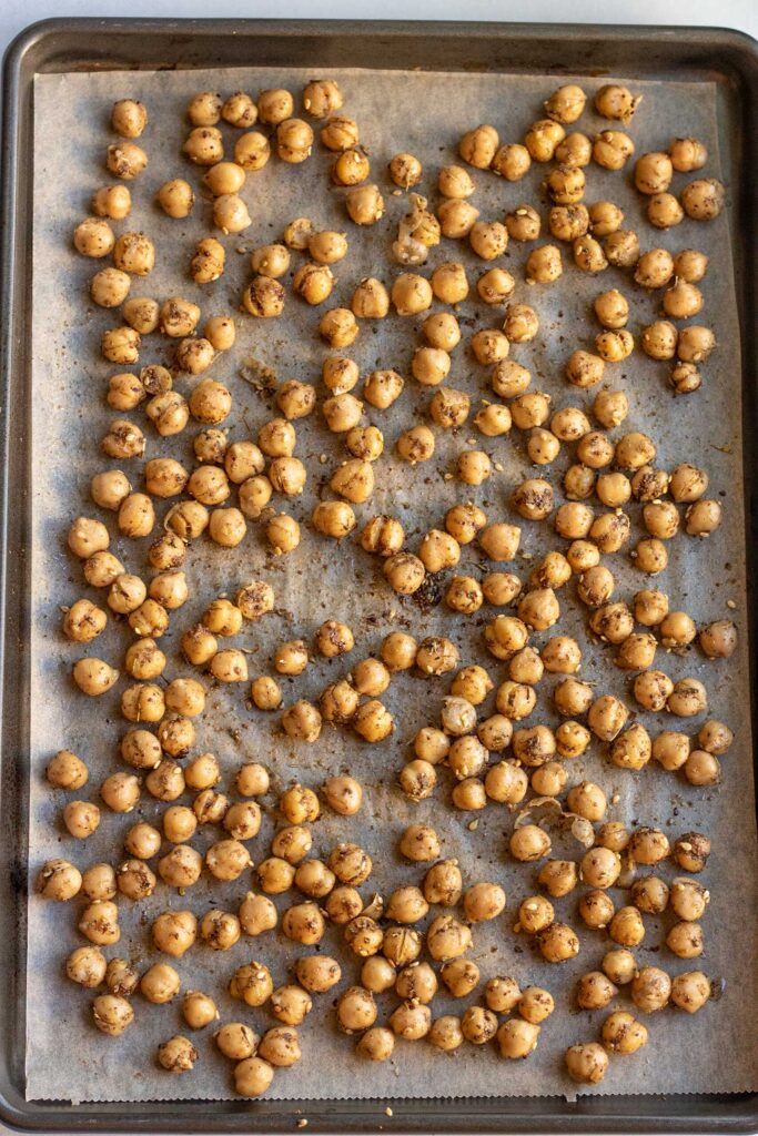 Chickpeas coated with za'atar and oil then spread on a baking tray.