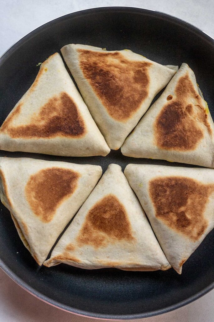 Toasted samosa wraps in a pan.
