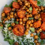 Close up of a large bowl of rice, roasted chickpeas and chickpeas and a side of herby yogurt.