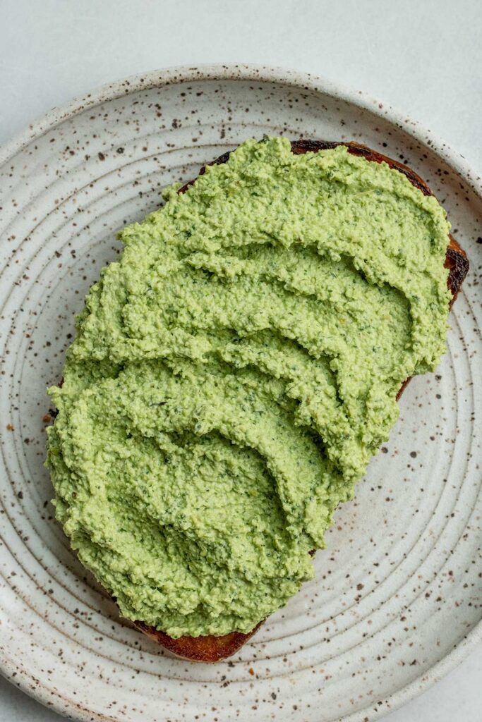 Toast topped with a swirl of basil edamame spread.