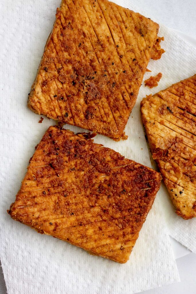 Pan seared tofu placed on paper towels to drain.