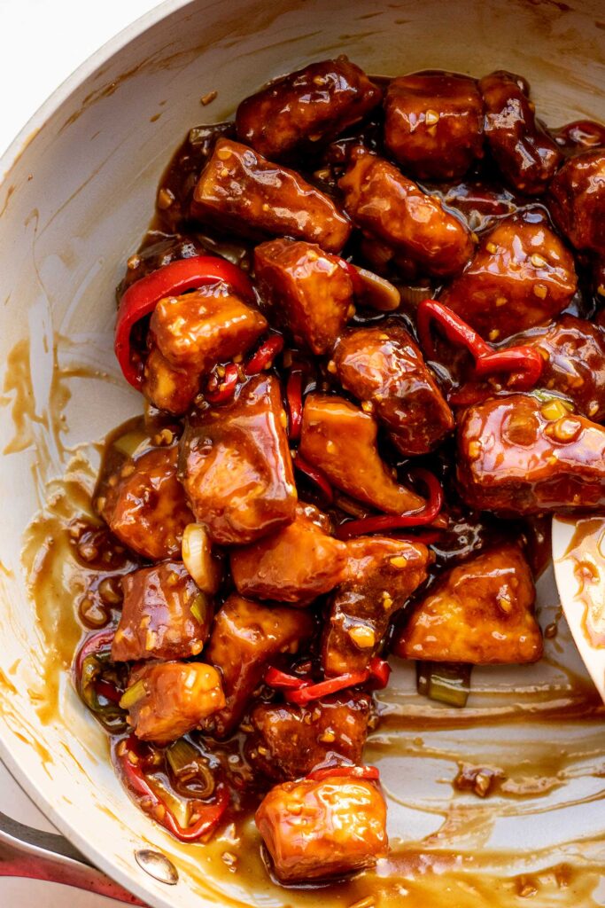 Coating the baked tofu in the thickened miso sauce in a pan.