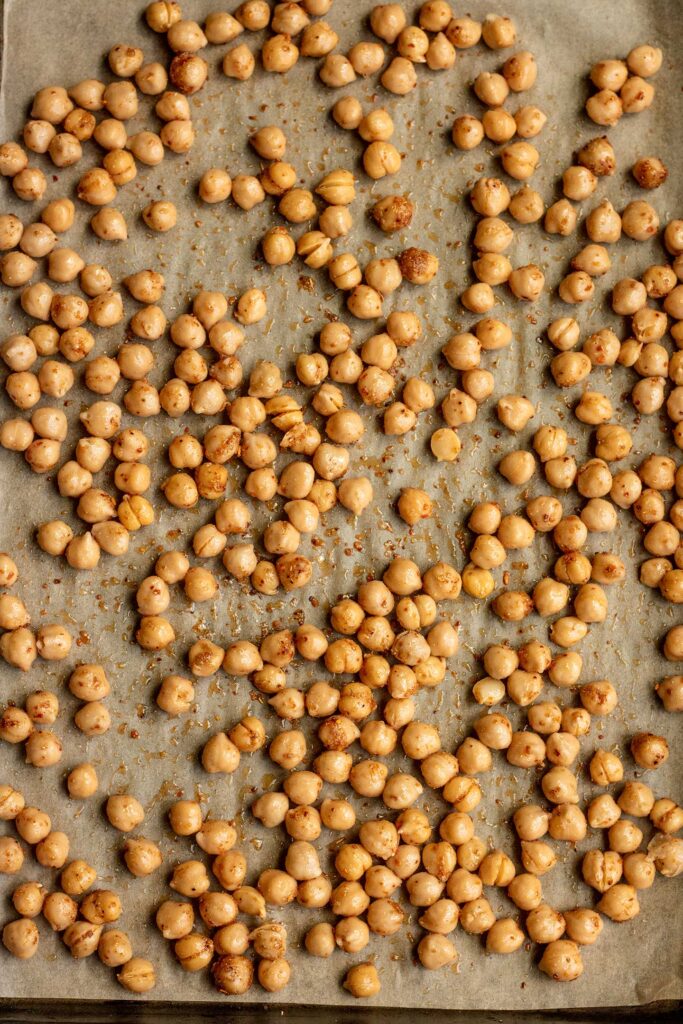 Chickpeas seasoned on a baking tray.