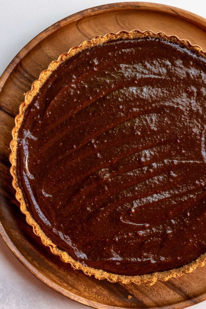 Chocolate filling spread out into the crust of the tart.