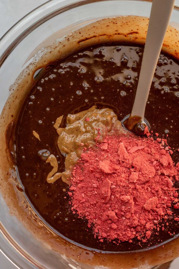 Stirring in the almond butter and freeze-dried strawberries.