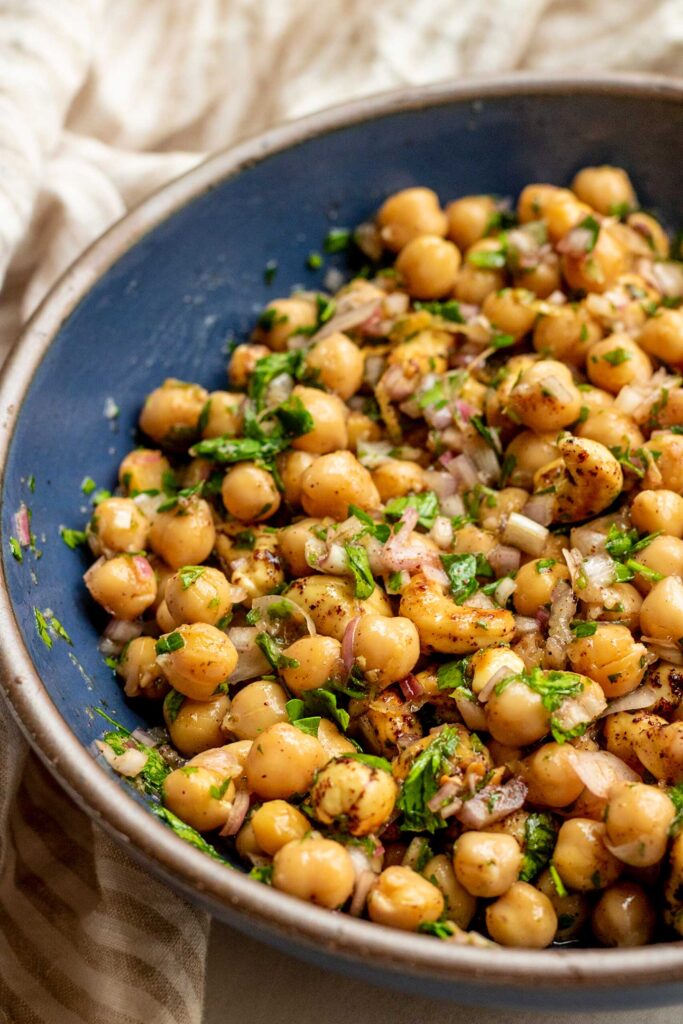 Side view of a bowl of chickpeas in a lemon marinade.