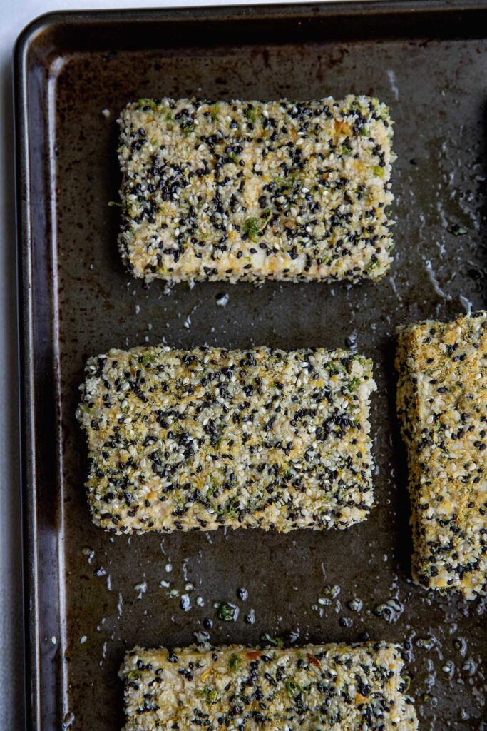 A baking tray with sesame coated tofu ready to bake.