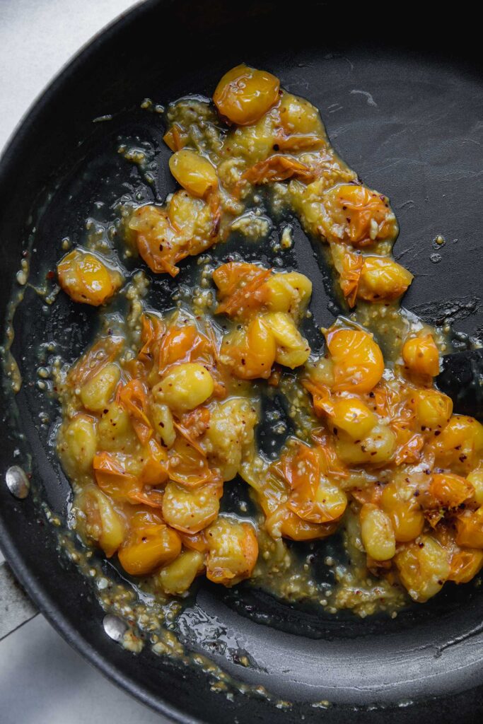 Stewed cherry tomatoes in a pan.