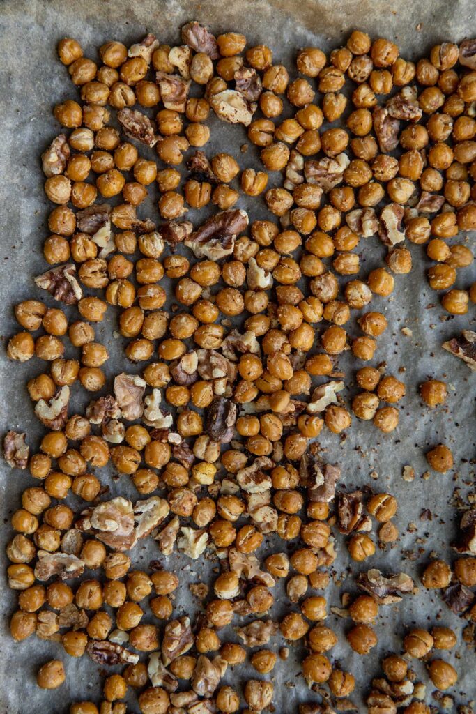 Roasted chickpeas and walnuts on a baking tray.