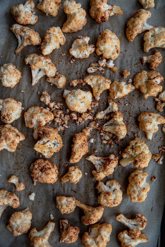 Seasoned cauliflower on a baking tray.