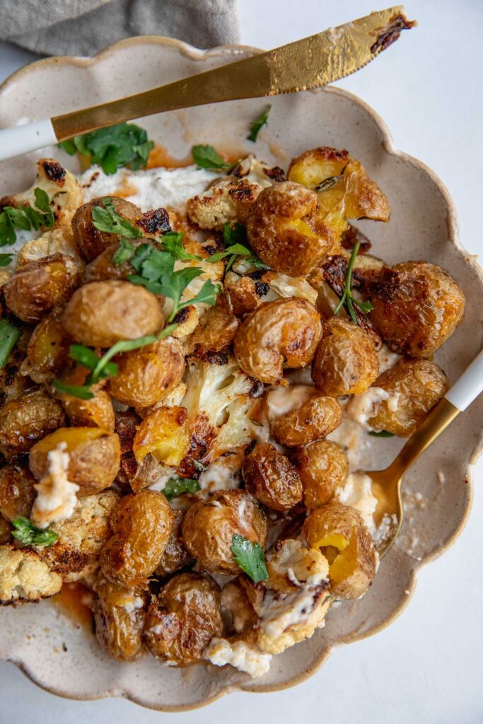 Mixed potatoes, cauliflower, dairy-free boursin and hot maple sauce on a plate.