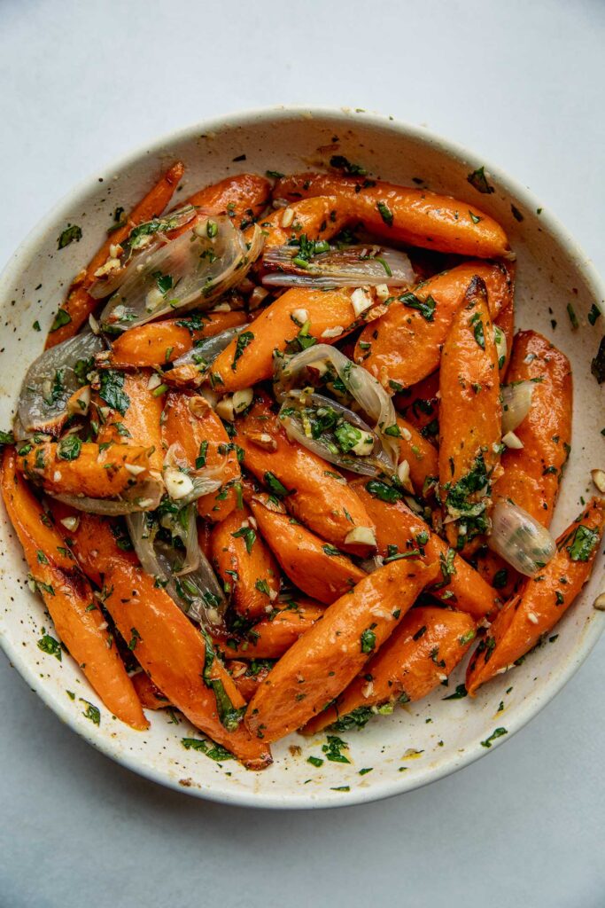 Roasted carrots tossed in a lemon glaze sauce in a bowl.
