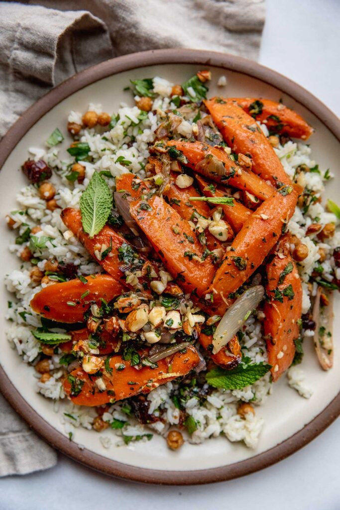 Platter of rice salad topped with roasted carrots, almonds and herbs.