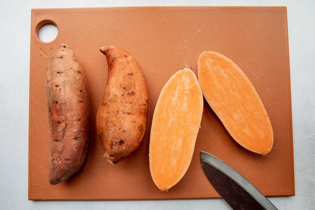 Cutting sweet potatoes in half.