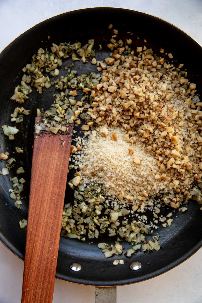 Toasting the breadcrumbs and walnuts together in a pan with herbs.