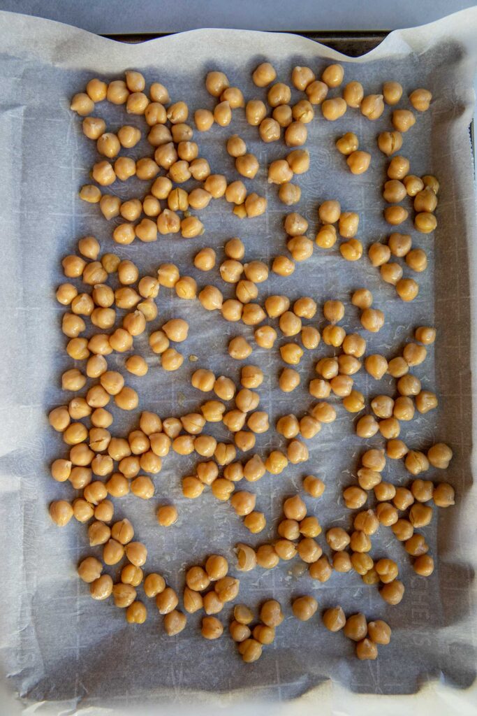 Seasoned chickpeas on a baking tray.