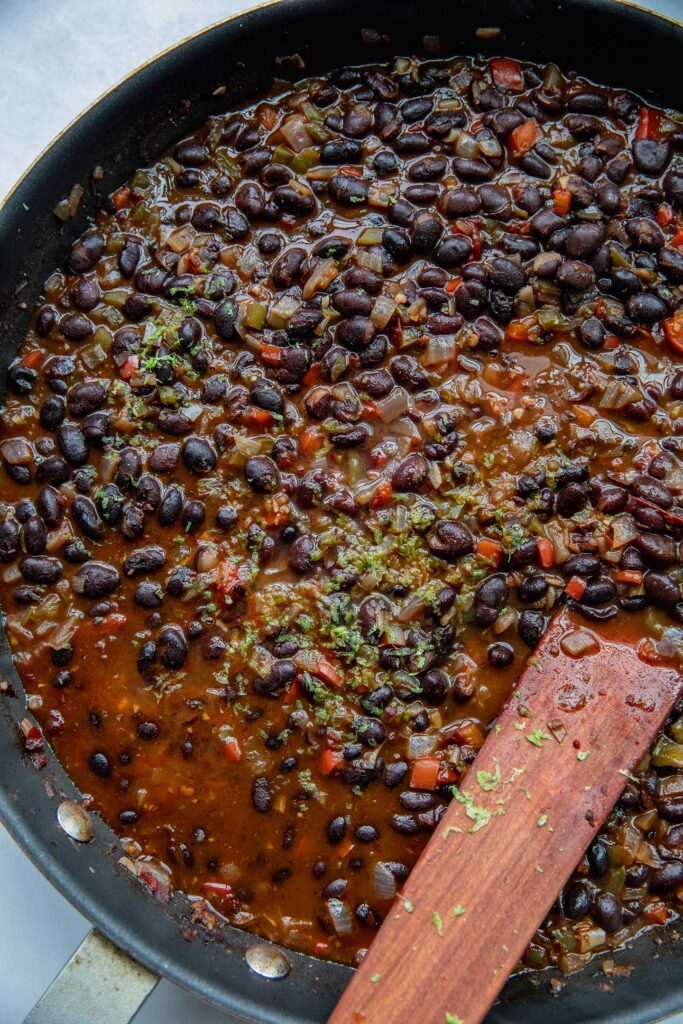 Stirring the lime juice and zest into the beans.