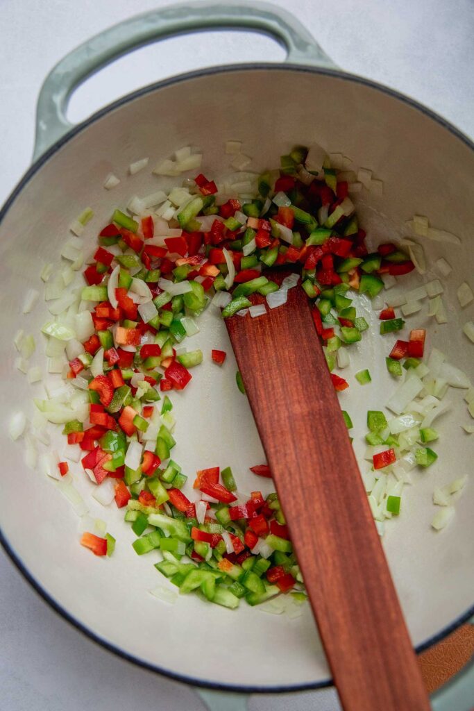 Sauteing the sofrito ingredients together in a pot.