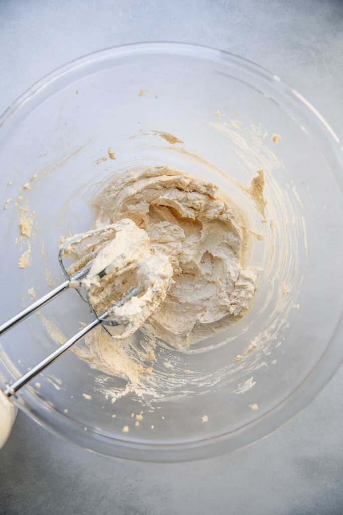 Beating the sugar and butter together with a hand mixer.