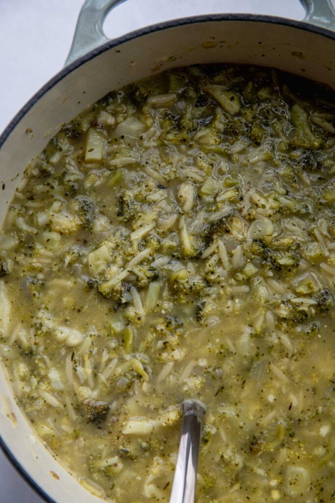 Broccoli orzo soup fully cooked in a soup pot.