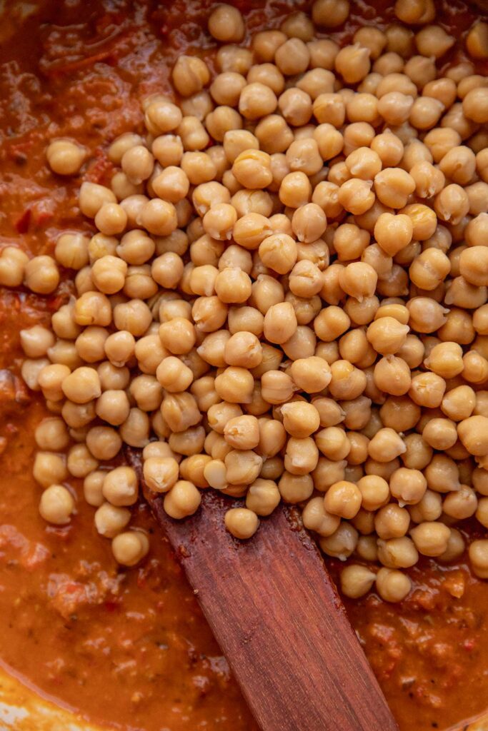Chickpeas added to the blended tomato sauce in a pan.