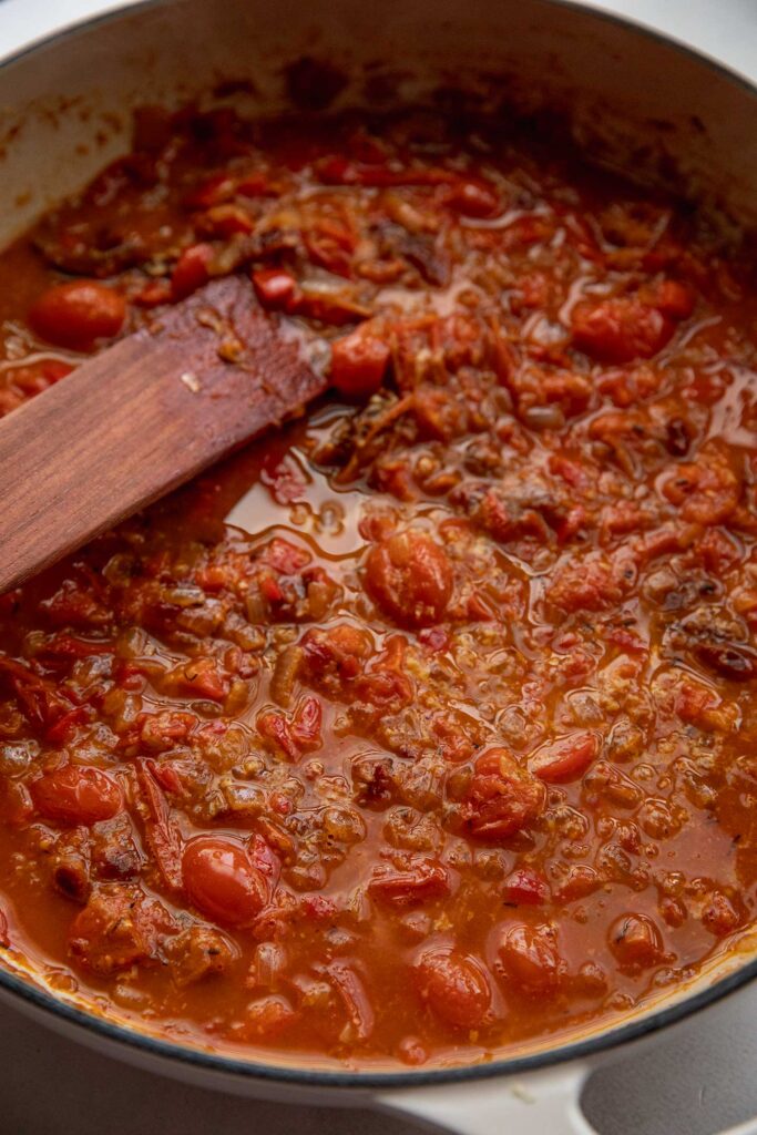 Stirring the partially blended tomato base with a spatula.