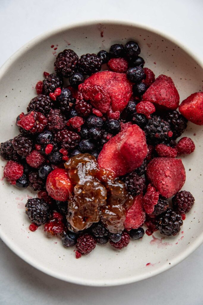 Mixing the berries together in a bowl with jam.