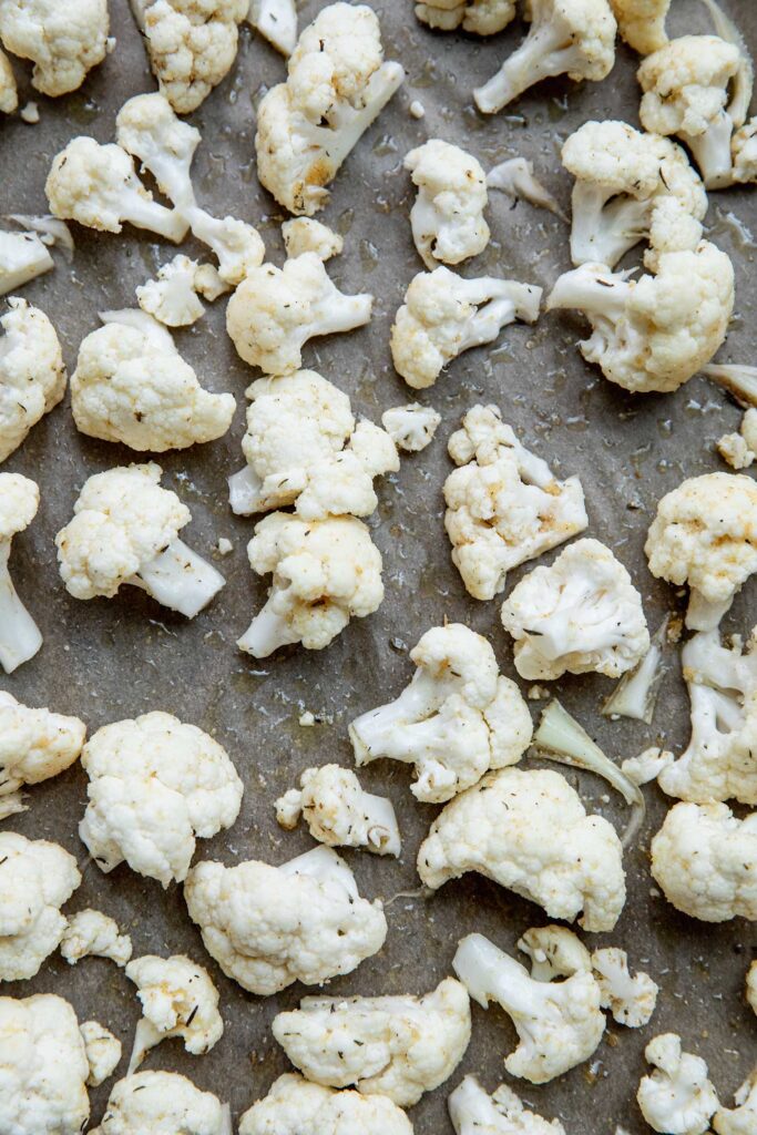 Seasoned cauliflower on a baking tray.