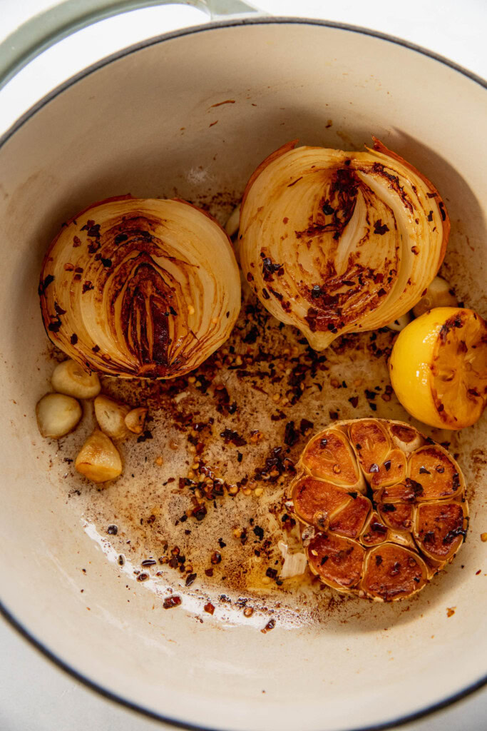 Topf gefüllt mit gerösteten Zwiebeln, Zitrone, Knoblauch und Pfefferflocken.