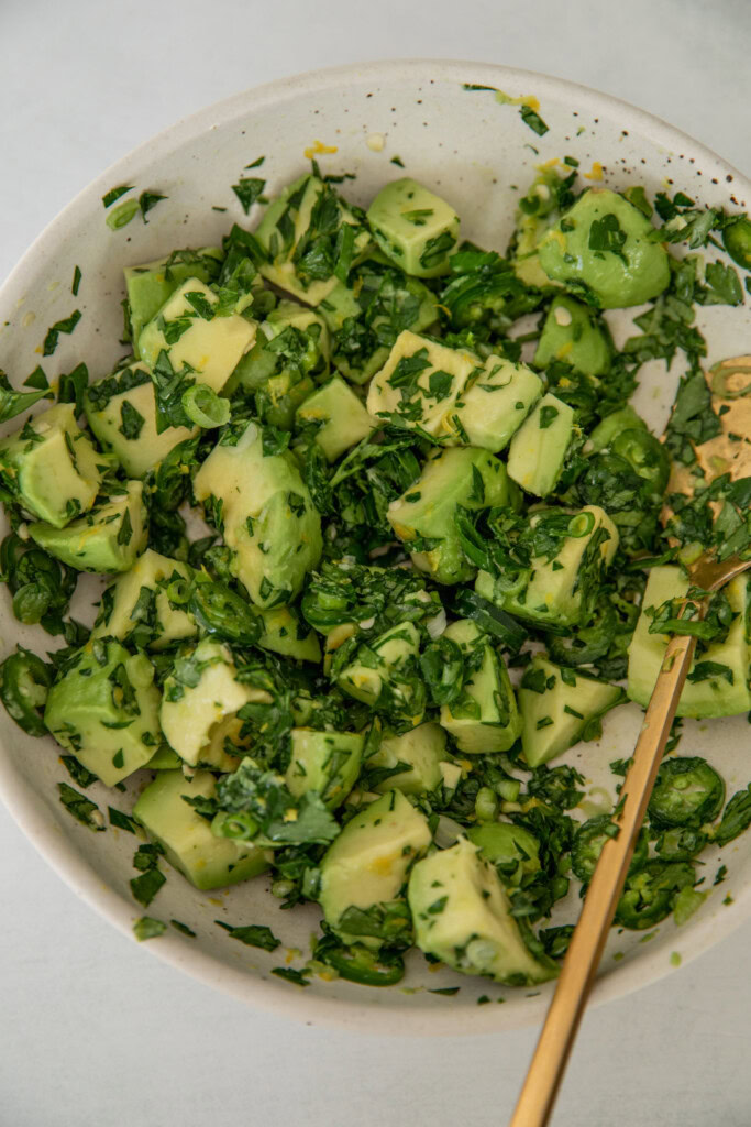 Schüssel mit gemischter Avocado-Frühlingszwiebel-Salsa.